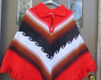 May include: Red, white, brown, and black striped knitted poncho with a fringe border. The poncho has a collar and a keyhole opening at the neck.