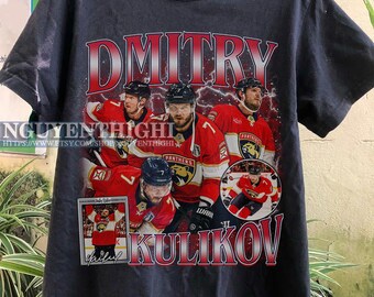 May include: Black t-shirt with a graphic print of hockey player Dmitry Kulikov wearing a red and black jersey with the text "Dmitry Kulikov" in red and white letters.