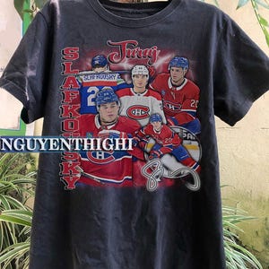 Könnte beinhalten: Schwarzes T-Shirt mit einer Collage von Hockeyspielern, die Trikots der Montreal Canadiens tragen. Die Spieler tragen die Nummern 2, 20 und 20. Der Text "Juraj Slafkovsky" ist auf dem Shirt gedruckt.