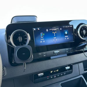 K&ouml;nnte beinhalten: Ein Armaturenbrett mit einem zentralen Bildschirm, der Telefon-, Radio- und Bluetooth-Symbole anzeigt. Bel&uuml;ftungs&ouml;ffnungen befinden sich auf beiden Seiten des Bildschirms. Ein kabelloses Ladepad ist angebracht. Die Temperaturanzeige zeigt 19 Grad Celsius an.