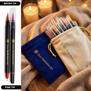 Puede incluir: Dos bol&iacute;grafos negros Zenn Meditation Art con puntas de pincel y finas, uno con tinta roja y otro con tinta rosa. Una bolsa de terciopelo azul con cord&oacute;n y una bolsa de terciopelo beige, ambas con el logo Zenn Meditation Art, contienen varios bol&iacute;grafos.