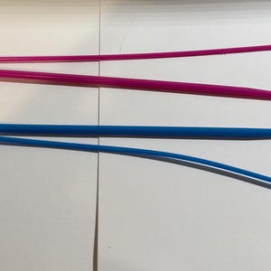 Puede incluir: Dos ganchos de ganchillo de plástico, uno rosa y otro azul. Los ganchos están diseñados con un bucle en cada extremo para una fácil manipulación del hilo.