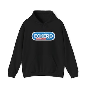 Puede incluir: Sudadera con capucha negra con un logotipo azul y rojo que dice "Eckerd Pharmacy" en una fuente desgastada.
