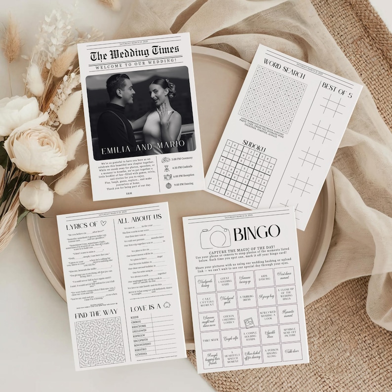 May include: A set of four white wedding activity cards featuring black text and graphics. One card displays a newspaper-style layout titled The Wedding Times with a photo of a couple, while others include word search, sudoku, bingo, and trivia games.