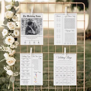 Pode incluir: Um expositor de grade de arame em ouro rosa segura quatro cart&otilde;es de atividades de casamento brancos presos com prendedores de roupa brancos. Os cart&otilde;es apresentam texto e gr&aacute;ficos pretos, incluindo um programa, um labirinto e um bingo.