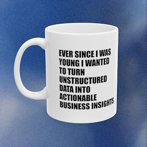 May include: White ceramic mug with a black text that reads: "EVER SINCE I WAS YOUNG I WANTED TO TURN UNSTRUCTURED DATA INTO ACTIONABLE BUSINESS INSIGHTS". The mug has a curved handle and a cylindrical shape.