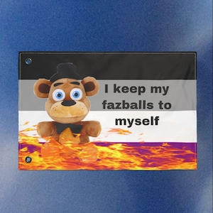 Könnte beinhalten: Flagge mit einem Plüschbär-Charakter und dem Text "I keep my fazballs to myself". Die Flagge hat ein schwarz-, grau-, weiß- und violettfarbenes Design mit einer feurigen orange-gelben Basis.
