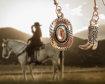May include: A pair of silver earrings with a cowboy hat and boot charm. The charms are detailed and have a vintage look.