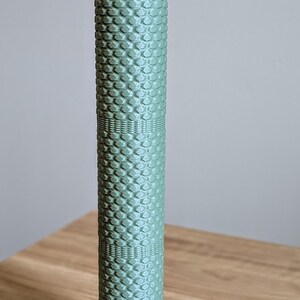 May include: A green foam roller with a textured surface. The roller is approximately 30 cm long and 7.5 cm in diameter.
