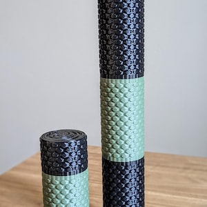 May include: Two foam rollers, one larger and one smaller, with a black and green honeycomb pattern. The rollers are made of a soft, textured material.