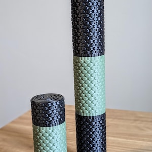May include: Two foam rollers, one green and black and one smaller green and black. The rollers have a textured surface.