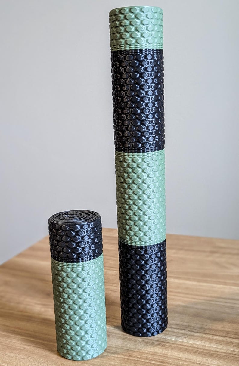 May include: Two foam rollers, one green and black and one smaller green and black. The rollers have a textured surface.