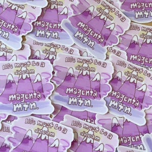 May include: A pile of stickers with a purple mountain range design and the text "magenta mtn." and "life must be a dream".