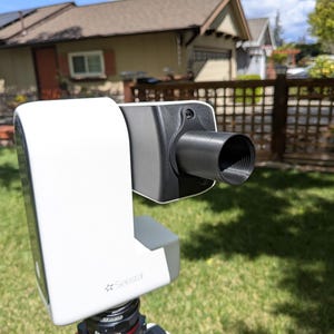 May include: A white 3D scanner on a tripod with a black lens. The scanner is labeled "See3D".