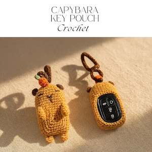 Pode incluir: Estojo de chaveiro de capivara de crochê em amarelo mostarda com detalhes marrons. Um estojo tem uma cenoura e chifres, o outro um chaveiro. O texto "CAPYBARA KEY POUCH Crochet" está no topo.