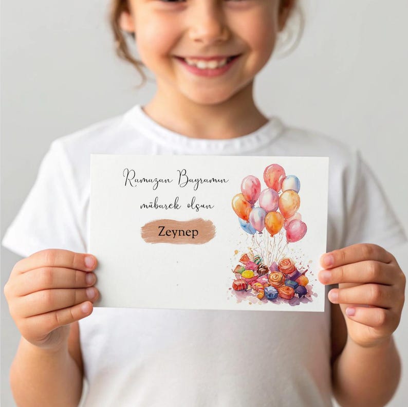 May include: A white card with the text "Ramazan Bayramin" and "mubarek olsun" in brown lettering. The card also has a gold name tag with the name "Zeynep" on it. The card has a watercolor illustration of colorful balloons and candy.