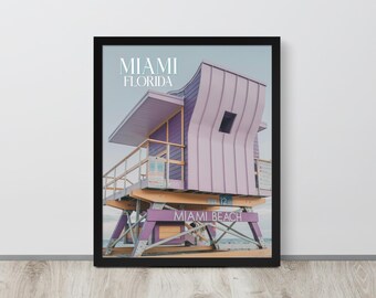 May include: A framed photograph of a purple lifeguard stand on a beach in Miami, Florida. The stand has a sign that reads "Miami Beach".