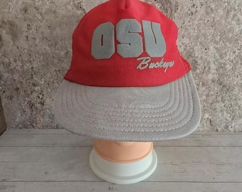 May include: A red and grey baseball cap with the letters "OSU" and the word "Buckeyes" embroidered on the front.