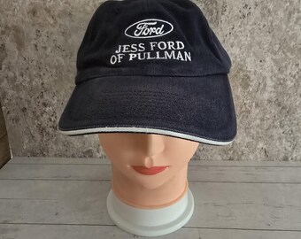 May include: A navy blue baseball cap with a white embroidered Ford logo and the text "Jess Ford of Pullman".