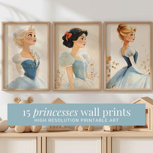 May include: Three framed illustrations of princesses in blue dresses. The princesses are Snow White, Cinderella, and Elsa. The frames are light brown wood. The text "15 princesses wall prints HIGH RESOLUTION PRINTABLE ART" is below the frames.