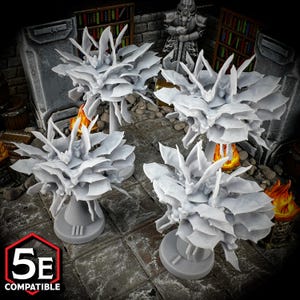 May include: Four miniature white plastic trees with a base, each with a cluster of leaves that resemble bat wings. The trees are arranged on a gray tiled surface.