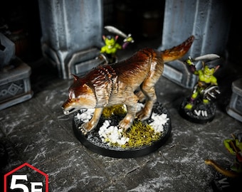 Puede incluir: Una miniatura pintada de un lobo marrón con ojos rojos, de pie sobre una base con hierba verde y nieve blanca. El lobo está en posición de gruñido, con la cabeza girada hacia un lado.