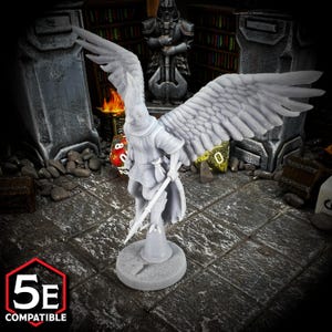 May include: A gray miniature figurine of a winged character holding a sword, designed for tabletop role-playing games. The figure has detailed wings and is standing on a circular base. The image includes the text "5E COMPATIBLE".