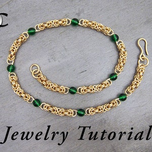 May include: Gold chain necklace with green beads. The chain is made of small, interlocking rings. The necklace has a clasp and a decorative loop. Jewelry Tutorial.