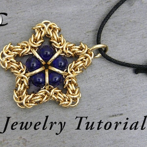 May include: Gold star-shaped pendant with blue glass beads in the centre, hanging from a black cord. Jewellery Tutorial.