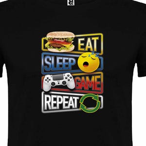 Peut inclure: T-shirt noir avec un motif graphique qui dit "Manger Dormir Jouer Répéter" avec un hamburger, un visage endormi, une manette de jeu vidéo et un symbole de recyclage.