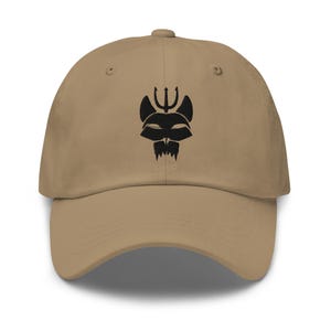 May include: A tan baseball cap featuring a black graphic of a stylized creature with a trident above its head. The cap has a curved brim and an adjustable strap at the back, suitable for various head sizes.