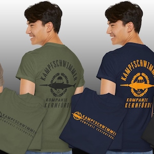 May include: Four t-shirts in various colors: tan, olive green, navy blue, and black. Each shirt features a circular graphic on the back with text and a fish design. The front of each shirt also displays a smaller version of the same graphic.