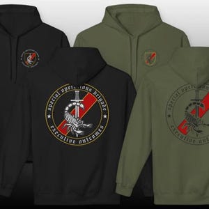 May include: Four hooded sweatshirts in black and olive green. The front of the black hoodie has a small emblem. The back of the black and olive green hoodies feature a circular design with a scorpion, sword, and text: "Special Operations Brigade Executive Outcomes."