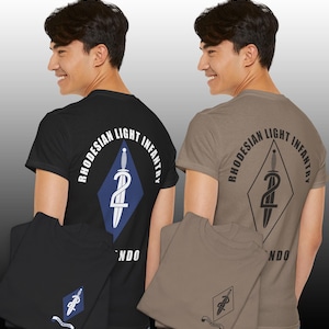 Puede incluir: Camisetas negras y color canela con el texto "RHODESIAN LIGHT INFANTRY" alrededor de un emblema en forma de diamante con una espada y el número 2. Las camisetas de manga corta muestran el mismo emblema en la parte delantera.
