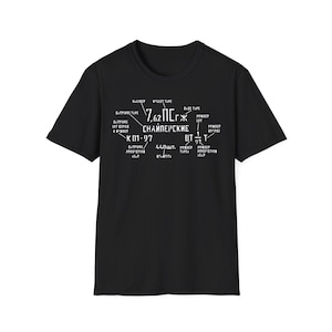 May include: Black t-shirt with white text featuring the numbers 7.62 and Cyrillic characters. The text also includes technical terms and numbers. The shirt has a crew neck.