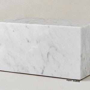 May include: White marble block with a smooth, polished surface. The block measures 10.25 inches by 5.6 inches by 5.2 inches and weighs 10 pounds. It has a capacity of 200 cubic inches.