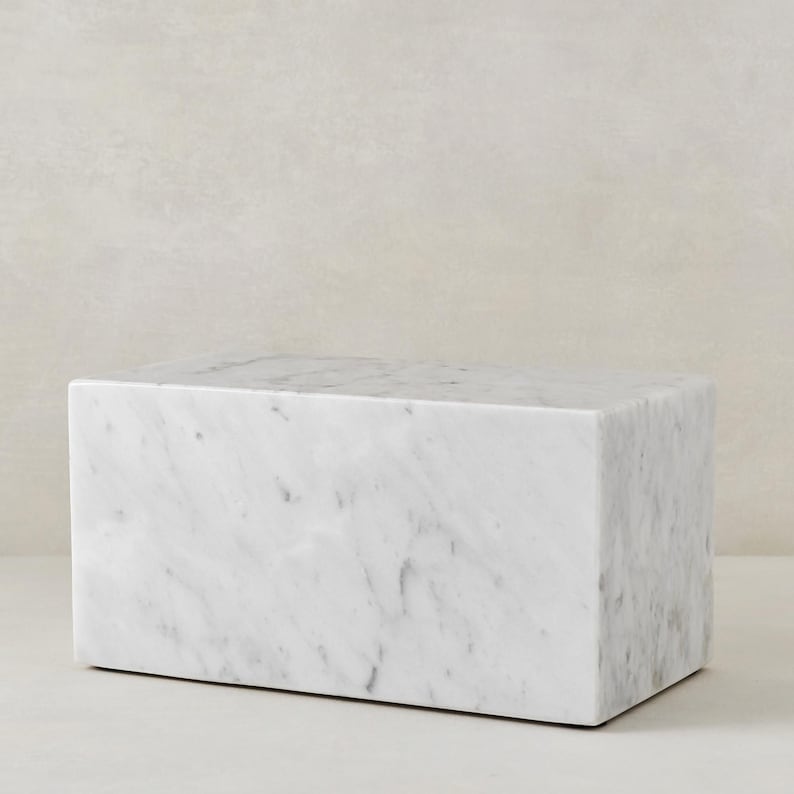 May include: A white marble rectangular block, perfect for displaying small items or as a decorative accent.