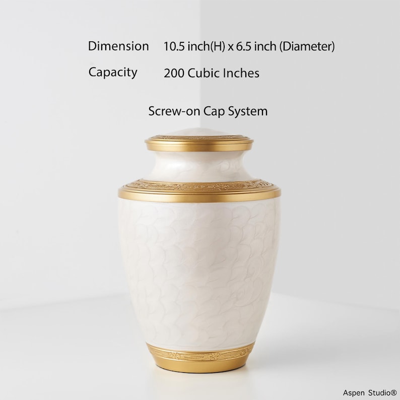 May include: A white urn with gold accents. The urn has a screw-on cap system and measures 10.5 inches high and 6.5 inches in diameter. The capacity is 200 cubic inches. The urn has a decorative floral pattern.