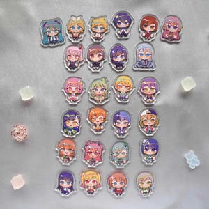 May include: A collection of 28 colourful anime character acrylic charms. Each charm features a different character with unique designs and expressions. The charms are perfect for adding a touch of personality to bags, backpacks, or keychains.