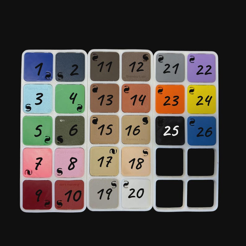 May include: A color swatch palette featuring twenty-six square tiles arranged in three white grids. Each tile displays a unique color, including shades of blue, green, pink, red, brown, gray, orange, yellow, and black, labeled with numbers 1 through 26.