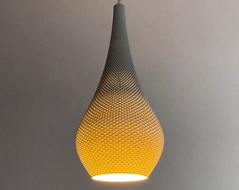 May include: A gray, teardrop-shaped pendant light fixture. The light fixture has a textured surface with a pattern of small, evenly spaced holes. The light emits a warm, yellow glow from within, creating a soft ambiance.