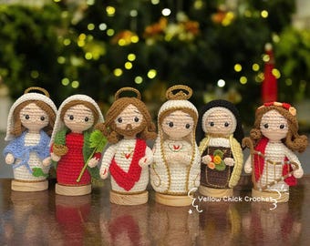 May include: A collection of six handmade crochet dolls, each depicting a religious figure. The dolls feature detailed facial expressions and are dressed in various colorful outfits. Each doll is mounted on a small wooden base, with the text "Yellow Chick Crochet" visible.