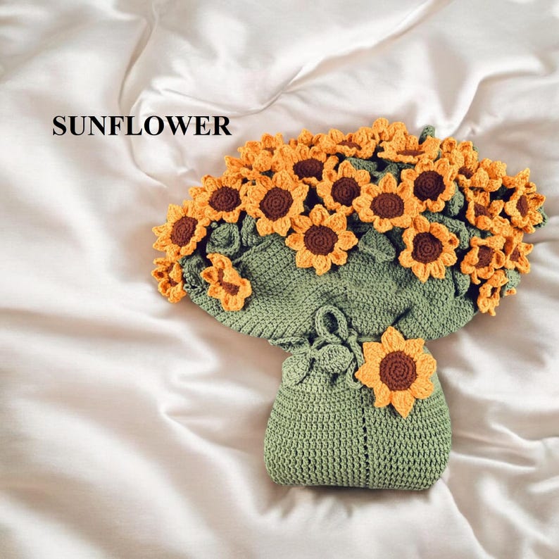 K&ouml;nnte beinhalten: Ein handgefertigtes geh&auml;keltes Sonnenblumenbouquet. Das Bouquet zeigt gelbe und braune Sonnenblumen mit gr&uuml;nen Bl&auml;ttern und eine gr&uuml;ne geh&auml;kelte Vase. Das Wort "SUNFLOWER" ist oben links in Schwarz gedruckt.