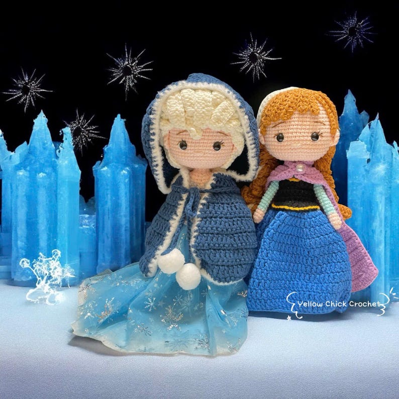 Pu&ograve; includere: Due bambole all'uncinetto, una con capelli biondi e un mantello blu con cappuccio, l'altra con capelli rossi e un mantello viola. Sono ambientate su uno sfondo di strutture di ghiaccio blu e decorazioni a fiocchi di neve. Le bambole indossano abiti blu.
