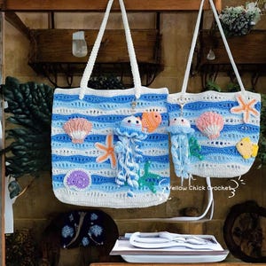 May include: Two crochet tote bags with white handles. The bags feature a blue and white striped pattern with various sea-themed appliqu&eacute;s, including jellyfish, starfish, seashells, and fish. The bags are handmade and have a beachy aesthetic.
