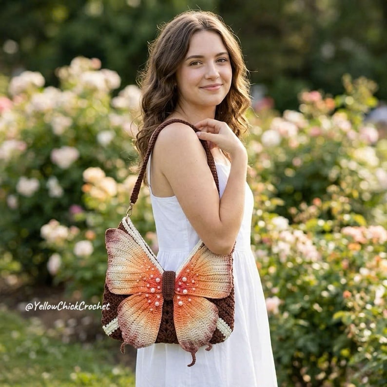 May include: A brown crochet shoulder bag featuring a large, three-dimensional butterfly design on the front. The butterfly wings are gradient orange and cream with small white pearl accents. The text YellowChickCrochet is visible on the image.