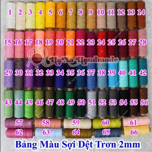 May include: A collection of 66 spools of 2mm round cord arranged in a grid, featuring a wide spectrum of colors including white, yellow, orange, pink, red, purple, blue, green, brown, and gray, with each spool labeled with a pink number.