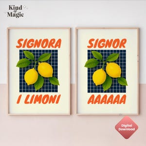 May include: Two framed art prints with a light beige background. Each print features a lemon branch with two lemons and the words "SIGNORA I LIMONI" and "SIGNOR AAAAAAA" in orange. The background is a dark blue grid.