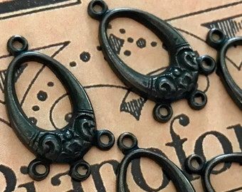 May include: Six antique bronze oval connector charms with decorative floral accents. Each charm has two loops at the top and three at the bottom for attaching to other jewelry components. The charms are arranged on a vintage paper background.
