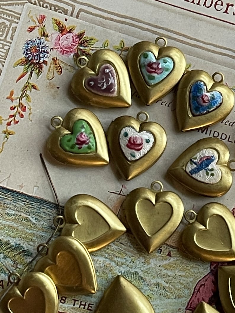 May include: A collection of gold heart-shaped locket charms with painted floral designs. The lockets have a hinged opening and are perfect for adding a personal touch to jewelry.